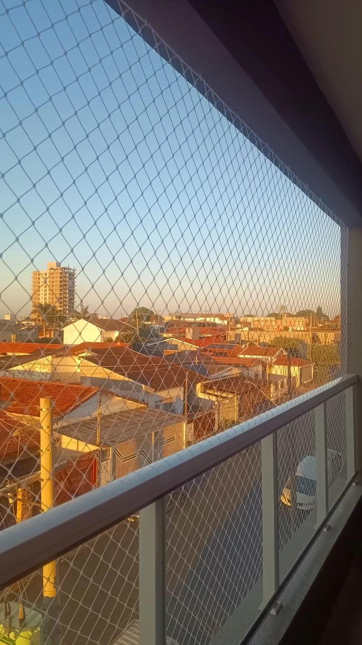 Varanda com rede de proteção branca instalada do teto ao guarda-corpo
